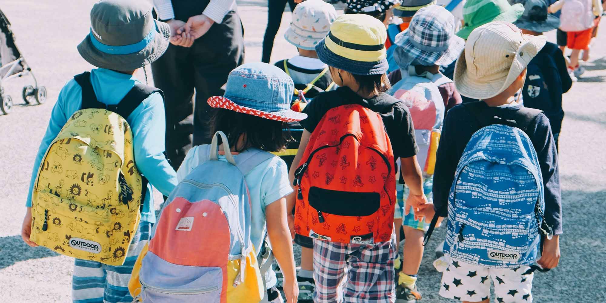 Grade school students walking with backpacks