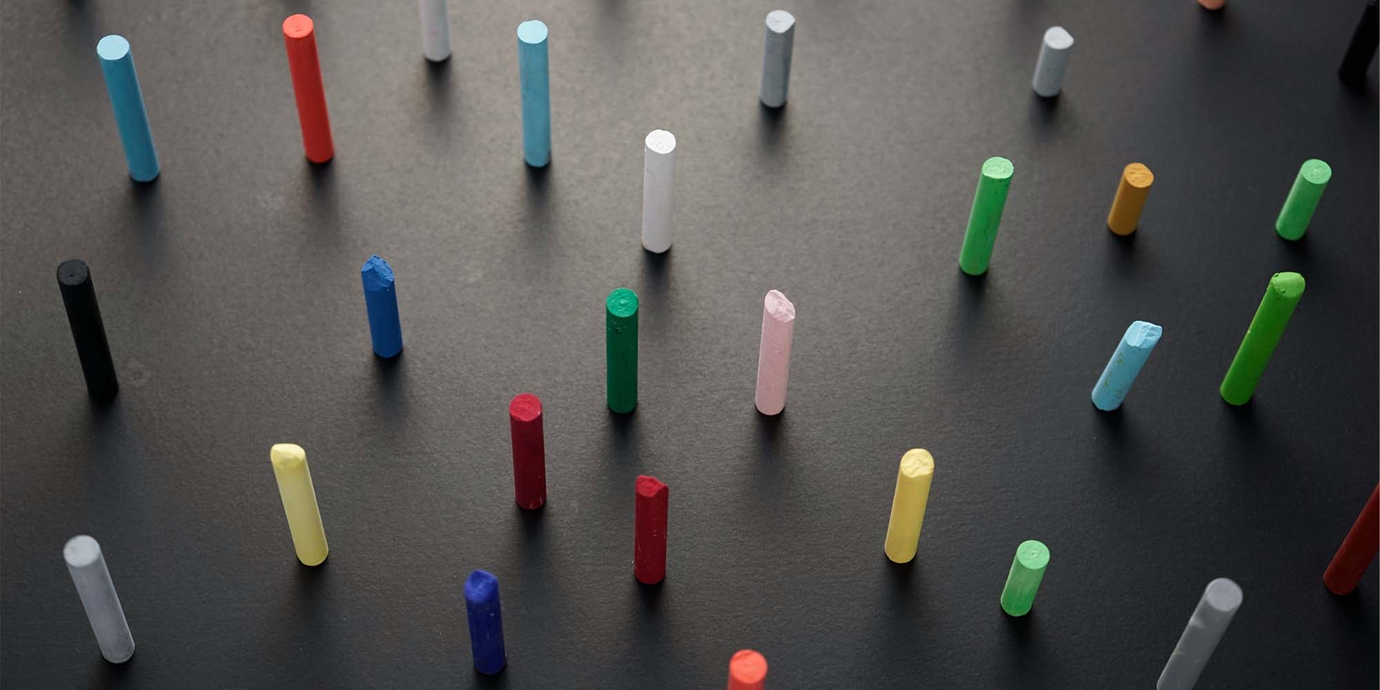 colorful chalk standing up on black surface